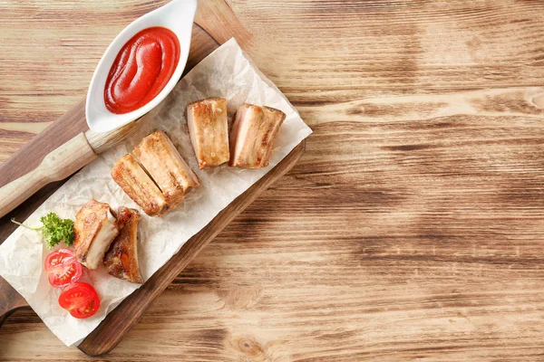 Holzbrett Mit Leckeren Gegrillten Rippchen Und Sauce Auf Dem Tisch — Stockfoto