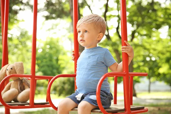 Sevimli küçük çocuk salıncaklar parkta oynamak