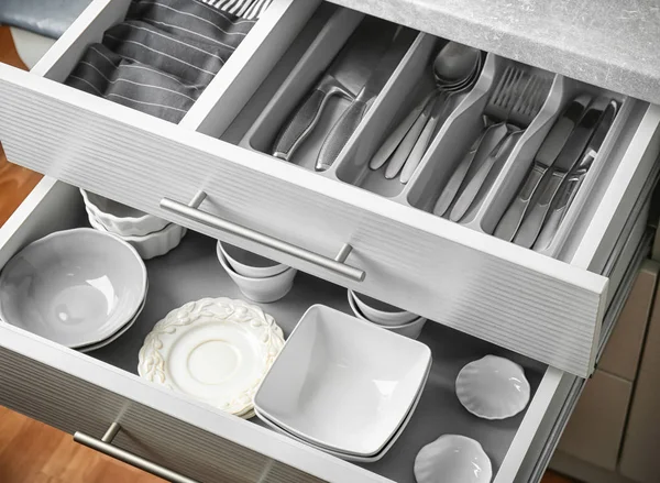 Ceramic dishware and cutlery in kitchen drawers