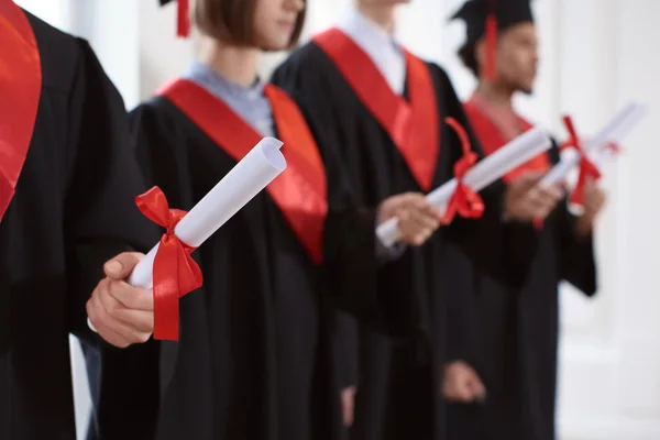 Studenten Bachelorroben Mit Diplomen Drinnen Abschlusstag — Stockfoto