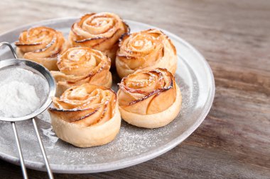 Puf böreği ahşap arka plan üzerinde elma gül ile plaka