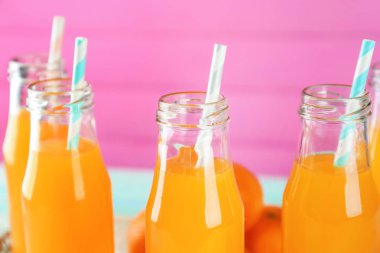 Renk arka plan üzerinde taze narenciye suyu şişeleri