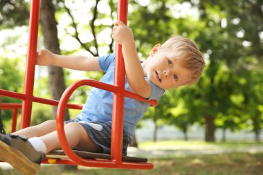 Sevimli küçük çocuk salıncaklar parkta oynamak