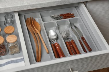 Set of cutlery and wooden utensils in kitchen drawer clipart