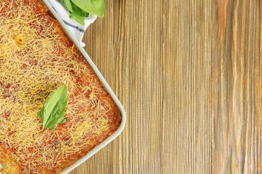 Ahşap masa üzerinde lezzetli ıspanaklı lazanya ile fırın tepsisi