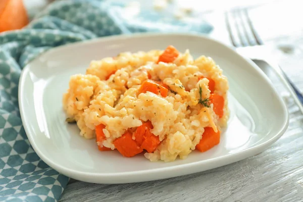 Ahşap masa üzerinde lezzetli kabak risotto ile plaka