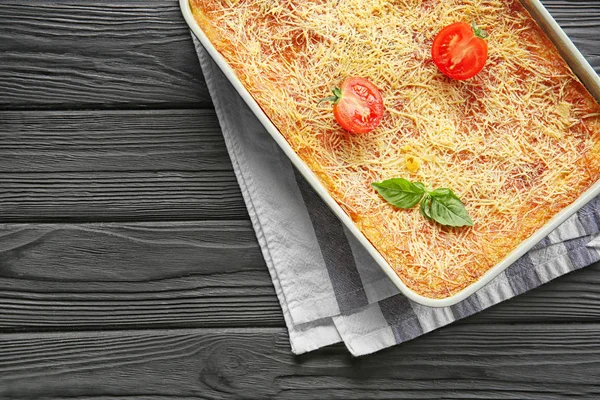 Ahşap masa üzerinde lezzetli ıspanaklı lazanya ile fırın tepsisi