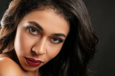 Siyah arka plan üzerine uzun kirpiklerini çekici Afrikalı-Amerikalı kadın. Kirpik uzantıları