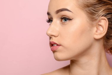 Renkli arka planda güzel kaşları olan genç bir kadın, yakın plan.