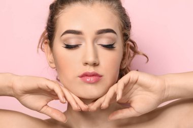 Renkli arka planda güzel kaşları olan genç bir kadın, yakın plan.