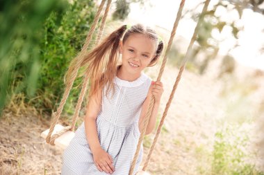 Salıncaklar parkta oynamak sevimli küçük kız