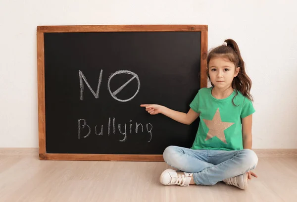 Kleines Mädchen Sitzt Neben Tafel Mit Worten Nein Zum Mobbing — Stockfoto