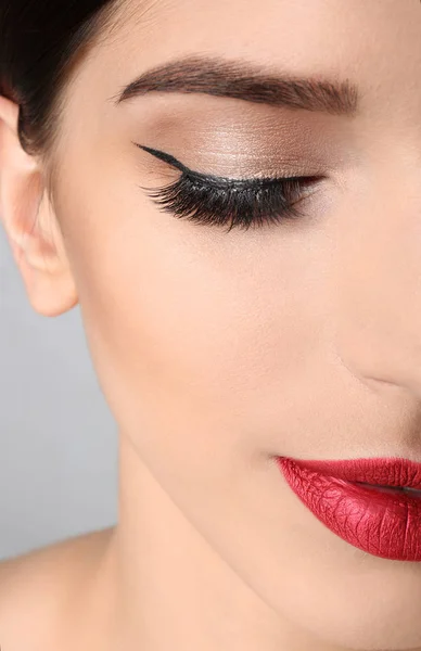 Mujer Joven Con Maquillaje Elegante Pestañas Largas Sobre Fondo Gris —  Fotos de Stock