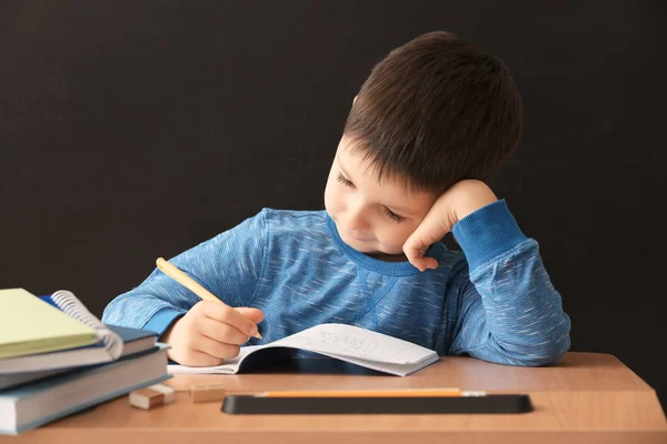 Netter Kleiner Junge Macht Hausaufgaben Vor Schwarzem Hintergrund — Stockfoto