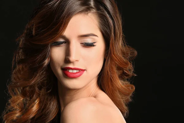 Zarif makyaj ve siyah arka plan üzerine uzun kirpiklerini çekici genç kadın. Kirpik uzantıları