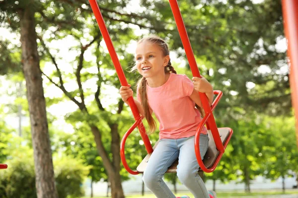 Salıncaklar parkta oynamak sevimli küçük kız