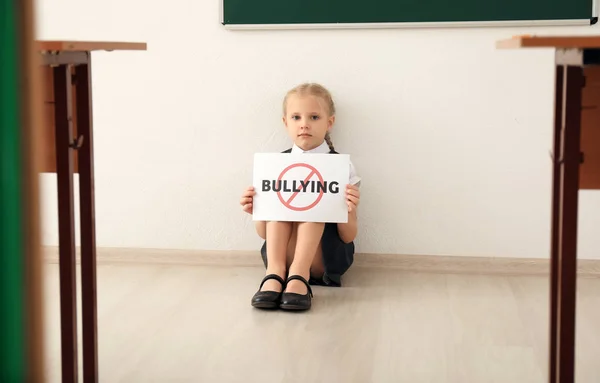 Niña Sentada Suelo Sosteniendo Cartel Con Palabra Cruzada Bullying Escuela — Foto de Stock