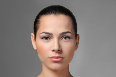 Gri arka plan üzerinde doğal kaşları olan kadın