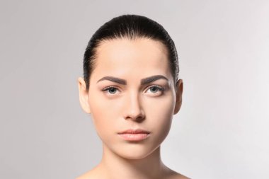 Kalıcı kaş makyaj gri arka plan üzerinde olan kadın