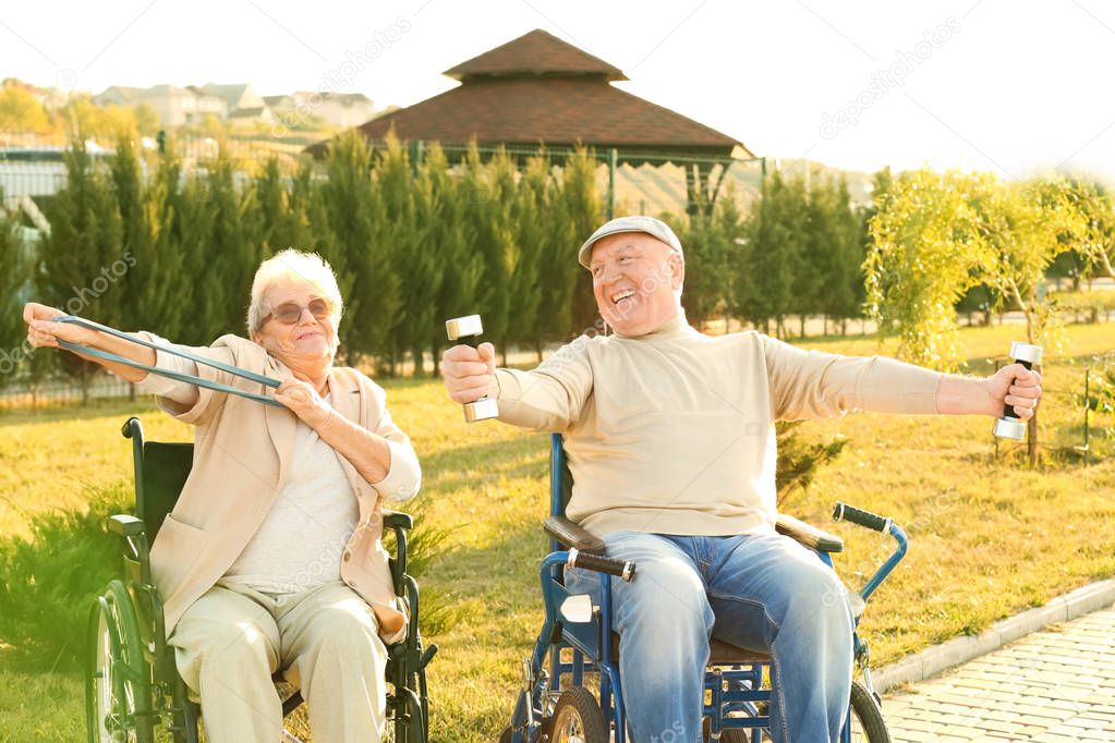 Senior man and woman from care home doing exercise outdoors