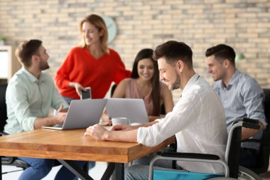 Tekerlekli sandalyeye mahkum işyerinde meslektaşları ile genç adam