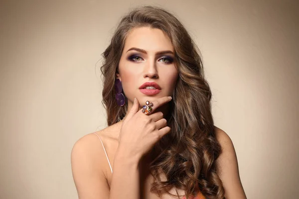 Schöne Junge Frau Mit Elegantem Schmuck Auf Farbigem Hintergrund — Stockfoto