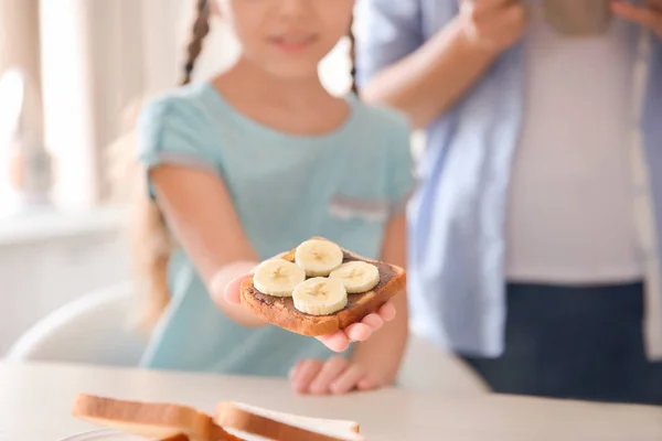 Gadis Kecil Memegang Roti Panggang Lezat Dengan Pisang Dan Pasta — Stok Foto