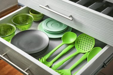 Set of dishware and kitchen utensils in drawer clipart
