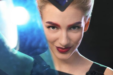 Koyu arka plan üzerine boyalı kaşlar olan kadın