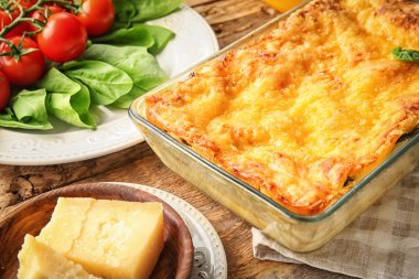 Ahşap masa üzerinde ıspanaklı lazanya ile fırın tepsisi