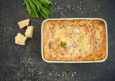 Gri zemin üzerine ıspanaklı lazanya pişirme çanağı