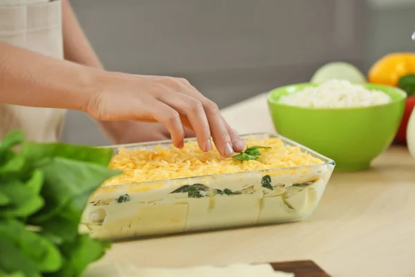 Kvinnan matlagning Spenatlasagne i köket — Stockfoto