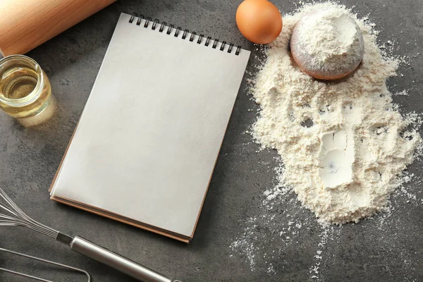 Anteckningsbok och produkter för att göra bröd på grå bakgrund — Stockfoto