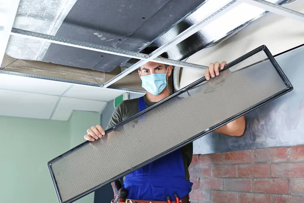 Técnico masculino limpieza acondicionador de aire industrial interior —  Fotos de Stock