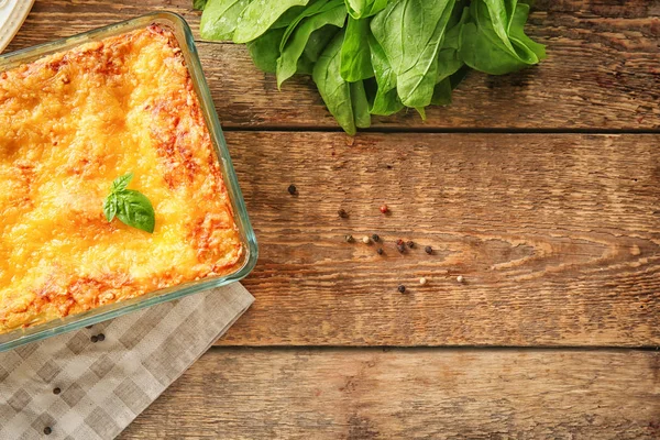 Baking tray with spinach lasagna on wooden table — Stock Photo, Image