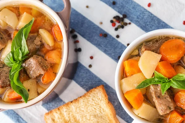 Caçarolas com carne saborosa e batatas na mesa — Fotografia de Stock