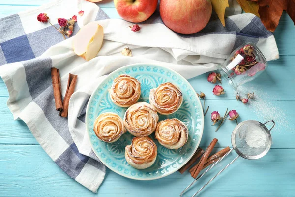 Tallrik med apple rosor från smördeg på färg träbord — Stockfoto