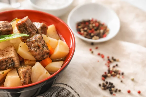 Bowl with tasty meat and potatoes on table — Stock Photo, Image