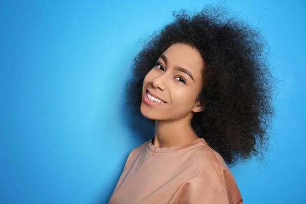 Atractiva mujer afroamericana posando sobre fondo de color —  Fotos de Stock