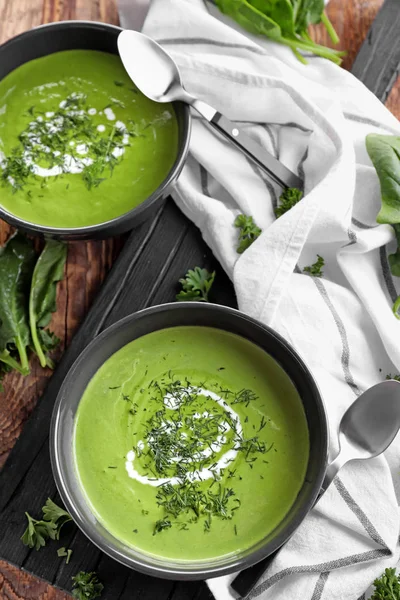 Bowls with delicious spinach soup on table — Stock Photo, Image