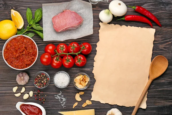 Zusammensetzung von rohem Fleisch mit Gemüse und Papier auf Holzgrund — Stockfoto