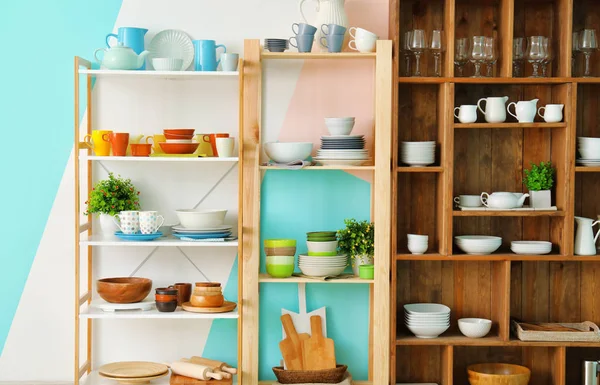 Different clean dishes on wooden shelves — Stock Photo, Image