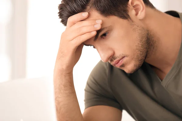 Portrait of serious young man on light background