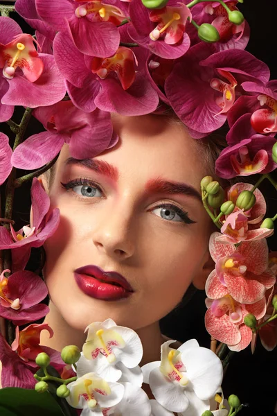 꽃으로 둘러싸인 염색 눈 썹 젊은 여자 — 스톡 사진