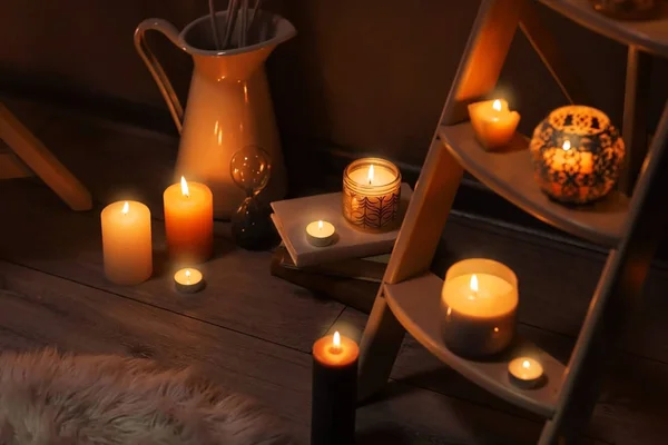 Деревянный стенд и горящие свечи в помещении — стоковое фото