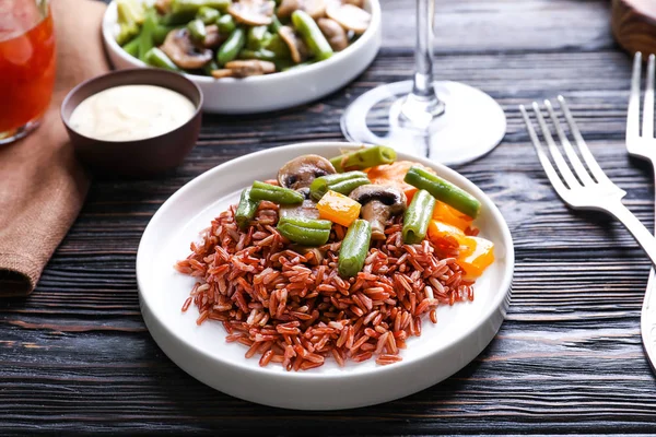 Piatto con delizioso riso integrale e verdure sul tavolo da pranzo — Foto Stock