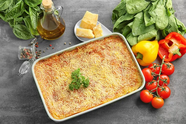 Composição com lasanha de espinafre saborosa, queijo e legumes na mesa — Fotografia de Stock