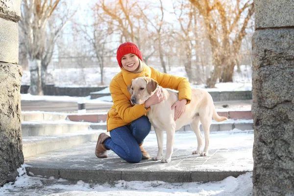 Frau umarmt niedlichen Hund im Freien an einem Wintertag. Freundschaft zwischen Haustier und Besitzer — Stockfoto