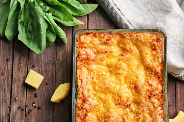 Deliciosa lasaña con espinacas y queso sobre fondo de madera —  Fotos de Stock