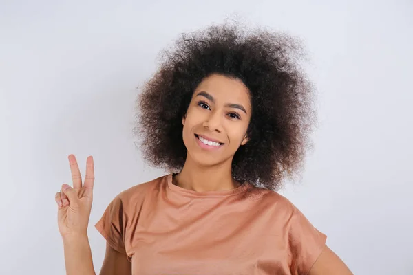 Attraktiv afroamerikansk kvinna poserar på ljus bakgrund — Stockfoto